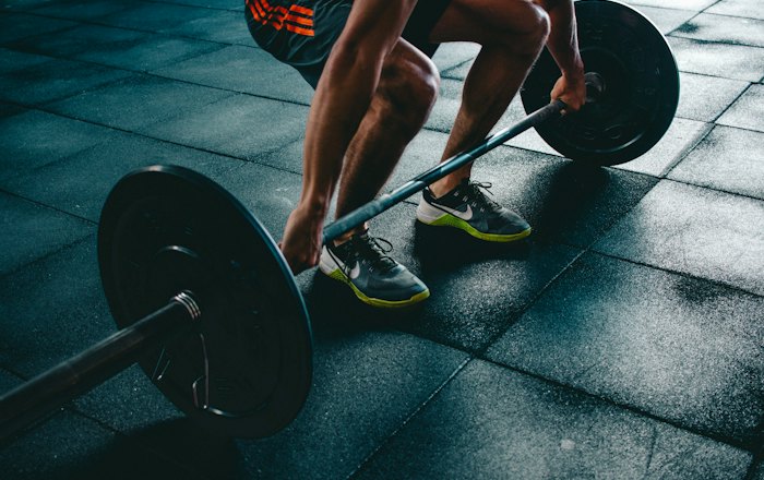 Sportiv pregătindu-se să ridice o haltă olimpică încărcată cu discuri